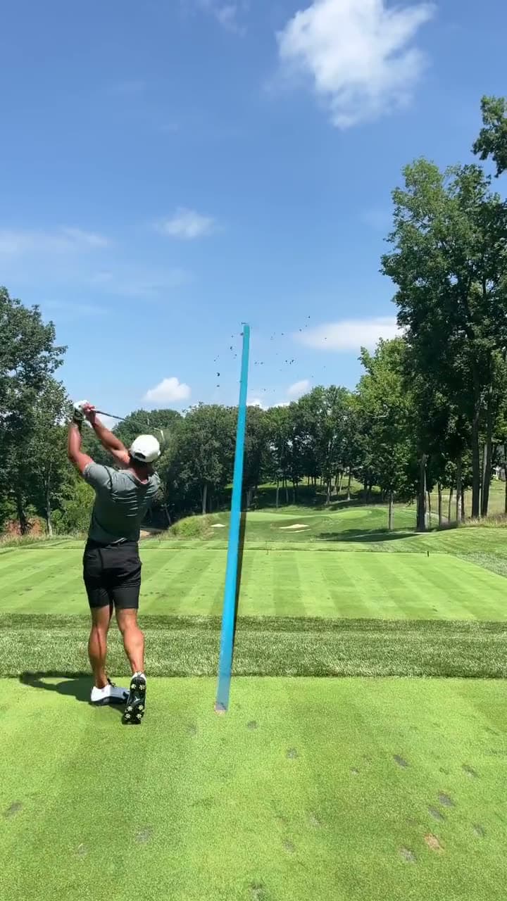 Golfer practicing bunker shots, hitting from the sand with the course behind